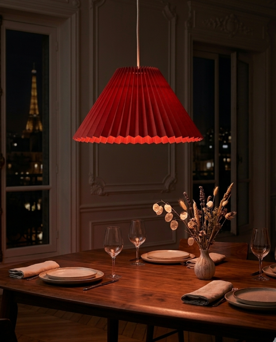 Abat-jour Sèvres rouge en suspension dans une salle à manger avec lumière chaude