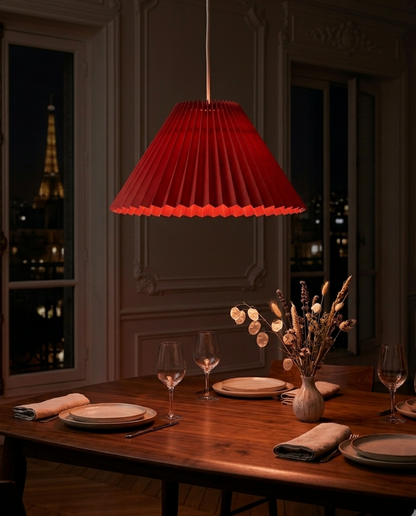 Abat-jour Sèvres rouge en suspension dans une salle à manger avec lumière chaude
