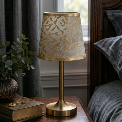Abat-jour Réaumur doré sur lampe de chevet dans une chambre claire